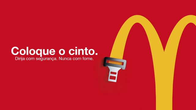M do McDonald's ligado à ponta de um cinto de segurança, com a frase "Coloque o cinto: dirija com segurança. Nunca com fome."